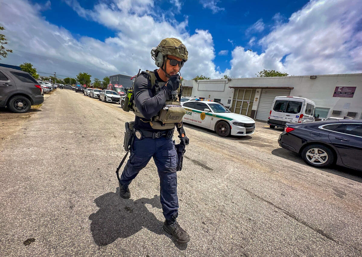 A deputy stands by as the Miami-Dade Sheriff’s Office investigates the shooting.